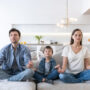 Family sits on the sofa and meditates
